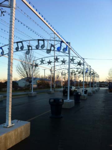 A photo of the Qty. 9 arches illuminated with Stars, Snowflakes and Music Notes. LED light strings were run from each arch to add to the festive mood (they also danced to the music).